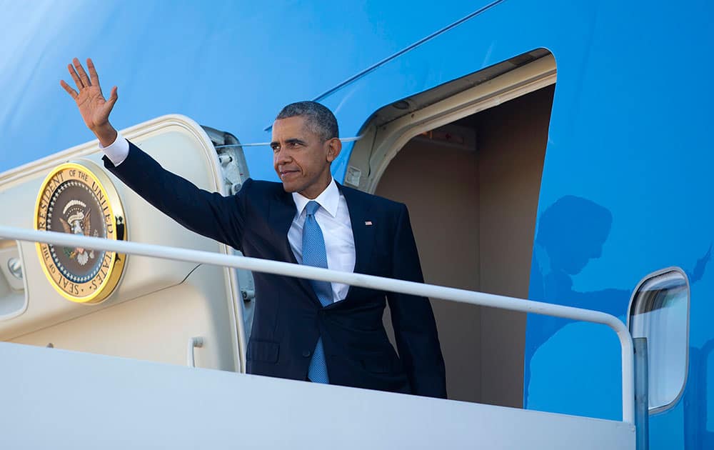 President Barack Obama waves as he boards Air Force One before his departure from Andrews Air Force Base, Md. Obama is traveling to Roseburg, Ore., to meet with families of the victims of the Oct. 1, shooting at Umpqua Community College, as part of a four-day West Coast tour. 