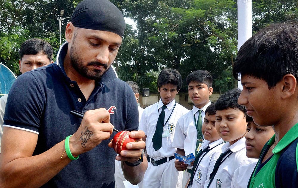 Harbhajan Singh giving autographs on a cricket ball to fan during a programme in North 24 Pargana district of West Bengal.