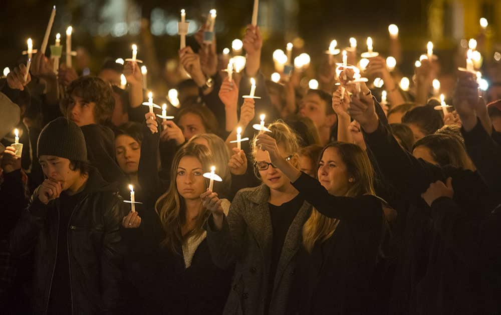 People participate in a candlelight vigil in support of the Northern Arizona University shooting victims, on the university campus in Flagstaff, Ariz.