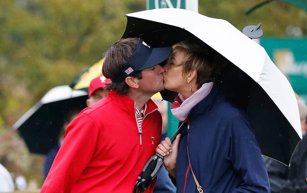 United States' Bubba Watson exchanges a kiss with his wife Angie during his singles match against International team player Thongchai Jaidee of Thailand at the Presidents Cup golf tournament at the Jack Nicklaus Golf Club Korea, in Incheon, South Korea.