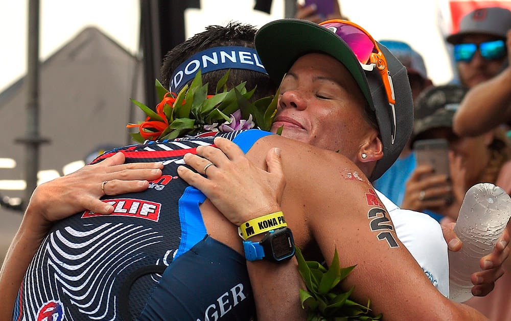 Timothy O'Donnell, left, hugs his wife and fellow competitor, Mirinda Carfrae, of Australia, after taking third in the men's portion of the Ironman World Championship triathlon in Kailua-Kona, Hawaii. 