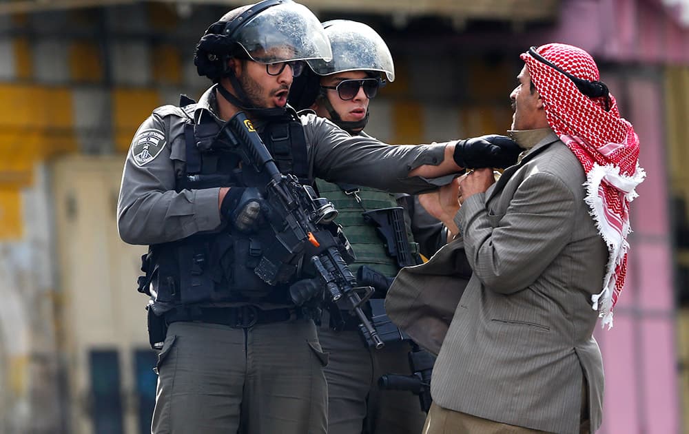 A Palestinian is pushed an Israeli policemen amid clashes in Hebron, West Bank.