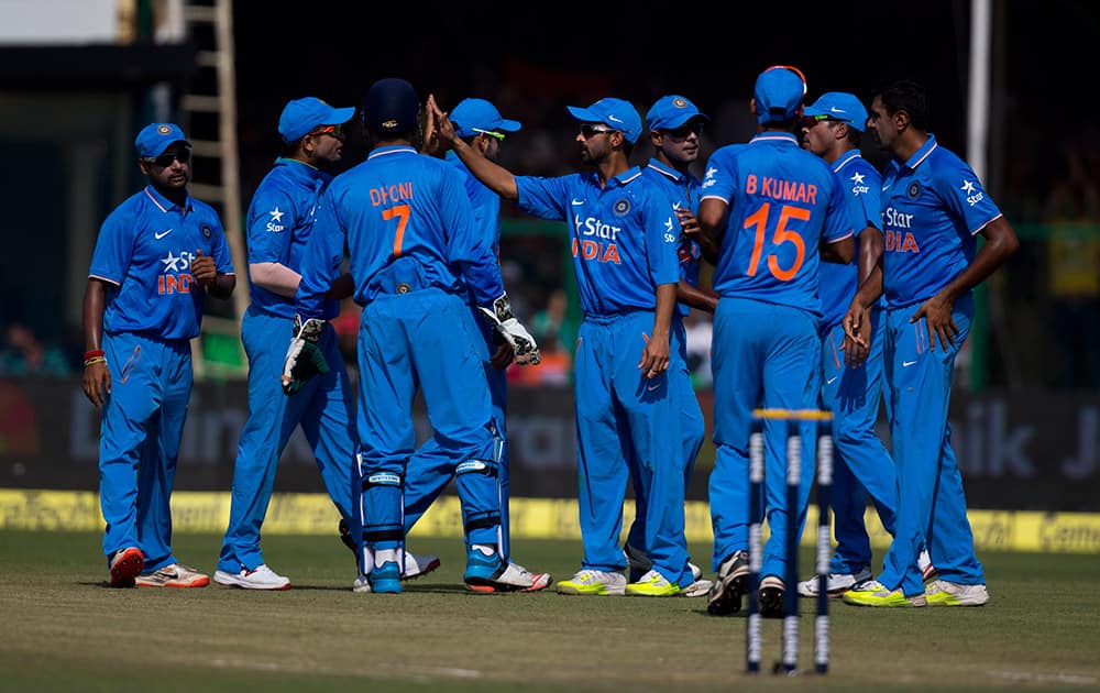 Indian cricketers celebrate the fall of South African batsman Quinton de Kock's wicket, during the first of their five one-day match series in Kanpur, India.