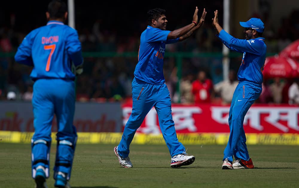 Indian bowler Umesh Yadav, center, celebrates with teammates after claiming a South African wicket in the first of their five one-day match series in Kanpur, India.