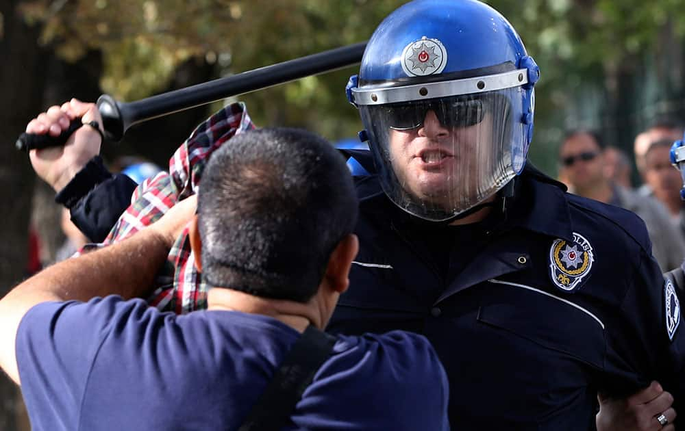 Turkish police officers in riot gear disperse protesters that tried to reach the site of Saturday's explosions to hold a memorial for the victims, in Ankara, Turkey.