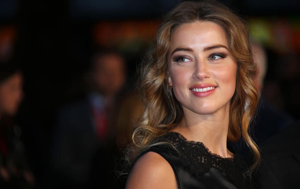 Amber Heard poses for photographers upon arrival at the premiere of the film Black Mass, as part of the London film festival in London.