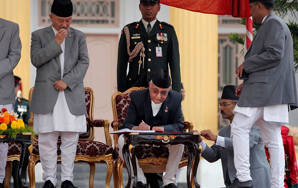 Constituent Assembly Chairperson of Nepal Subash Chandra Nemwang watches as newly elected Prime Minister Khadga Prasad Oli signs documents after administrating the oath of office at the Presidential building in Kathmandu, Nepal.