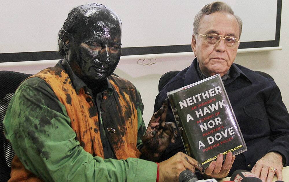 Former ideologue of the BJP Sudheendra Kulkarni, with face blackened by Shiv Sena activists, and former Pakistan foreign minister Khurshid Mahmud Kasuri showing the latters book at a press conference in Mumbai.