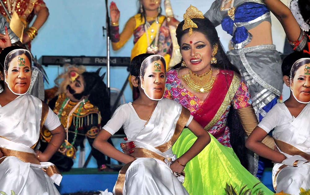 Little girls wearing mask of West Bengal Chief Minister and Trinamool Congress supremo Mamata Banerjee during a dance performance as dancer Ananya Banerjee (C) looks on at release of Festive Edition of Trinamool Congress mouthpiece Jagobangla on the occasion of Mahalaya, in Kolkata.