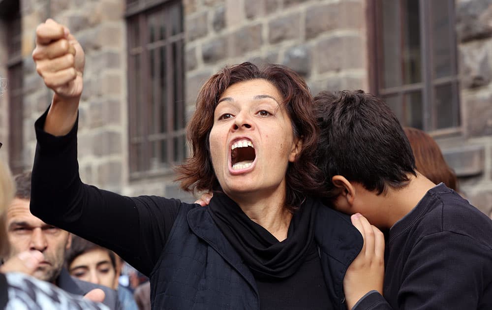 Emel Kitapci, the wife of Ali Kitapci, one of the victims from Saturdays bomb attacks, reacts as she stands with her son Artun Siyah Kitapci, 11, during a demonstration at the site of the explosions, in Ankara, Turkey.
