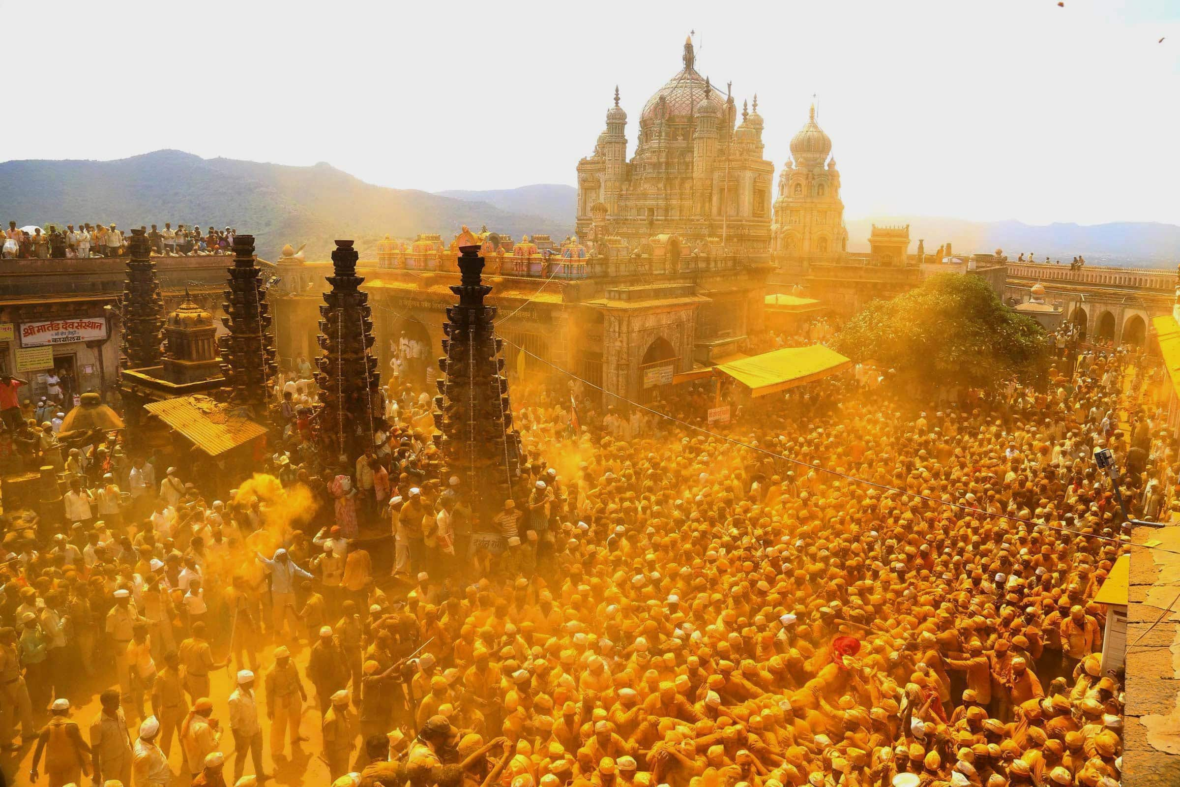 Devotees throw turmeric powder as an offering to the shepherd god Khandoba on the eve of Somavati Amavasya at Jejuri temple in Pune.