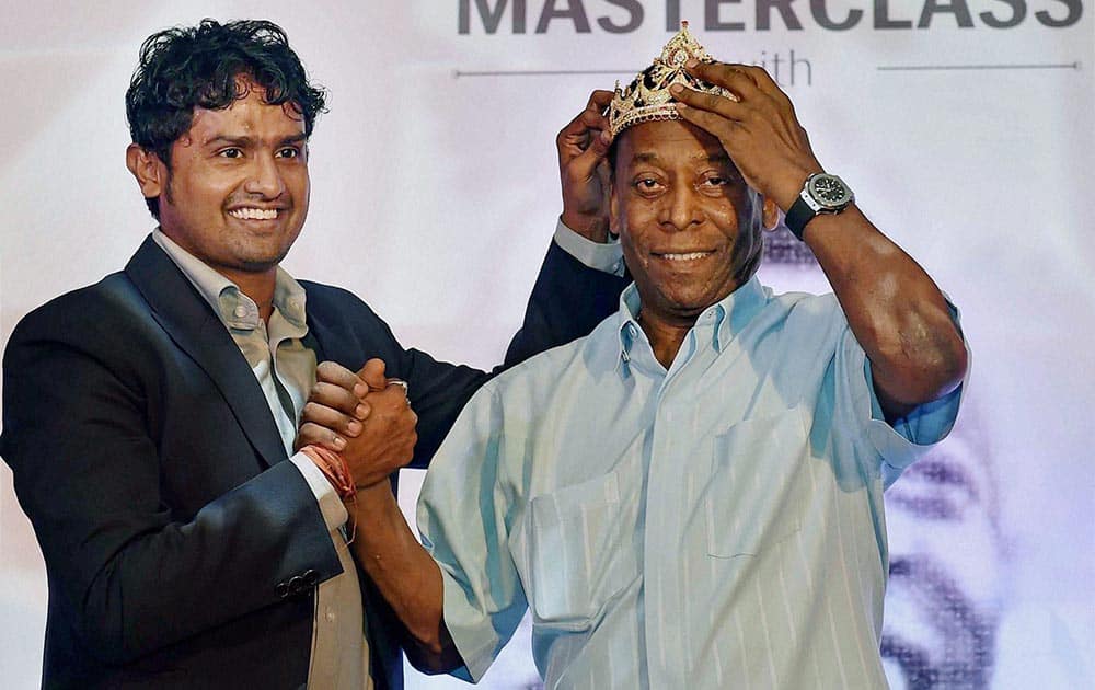 Indian footballer Dipendu Biswas presents a crown to legendary Brazilian footballer Pele during a promotional event in Kolkata.