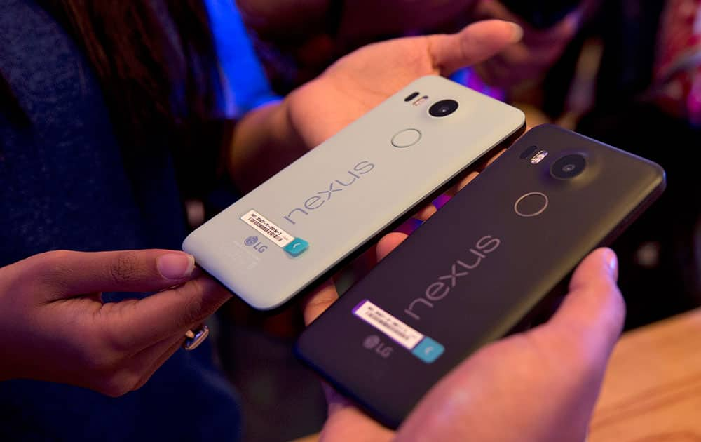 People hold the new Google Nexus phones during the launch of its latest range of Nexus 5X and Nexus 6P in New Delhi.