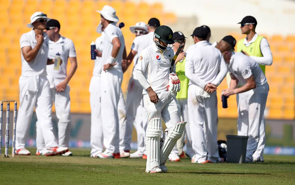 Pakistan batsman Muhammed Hafeez walks back for 98, after being dismissed by England's Ben Strokes, during the first day of the first test match between England and Pakistan at the Zayed Cricket Stadium in Abu Dhabi, United Arab Emirates.