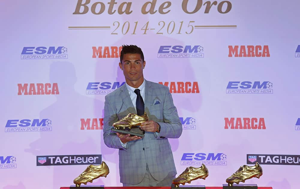 Real Madrid's striker Cristiano Ronaldo poses with the Golden Boot award for scoring the most goals in Europe's domestic leagues last season during a ceremony in Madrid, Spain.