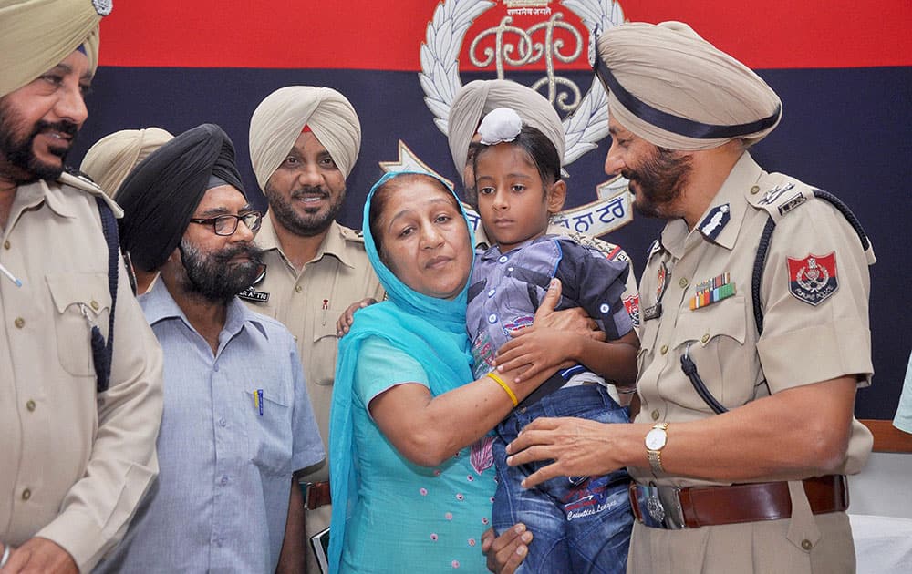 S. Paramjit Singh Gill, IPS, Inspector General of Police, Zonal-I hands over a child to his parents after he was freed from kidnappers at Police Line in Patiala.