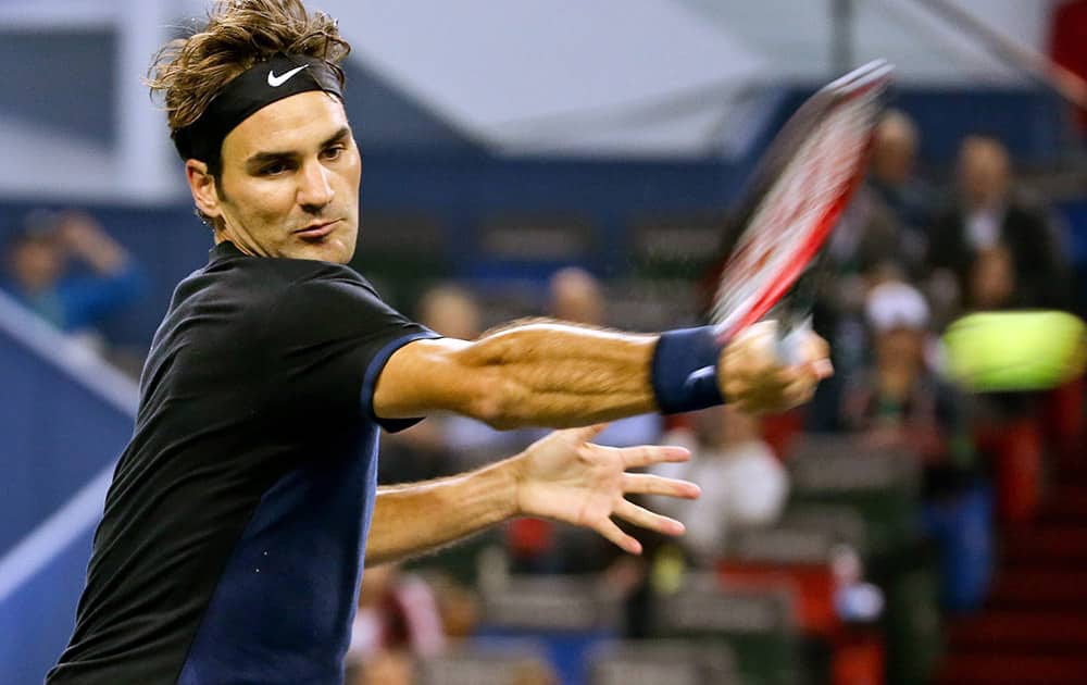 Roger Federer of Switzerland hits a return shot while playing against Albert Ramos-Vinolas of Spain during their mens singles match at the Shanghai Masters tennis tournament.
