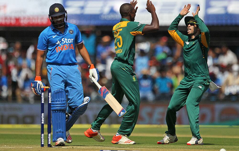 Rohit sharma leaves the field as south african cricketers celebrate his dismissal during their second one-day international cricket match in Indore.