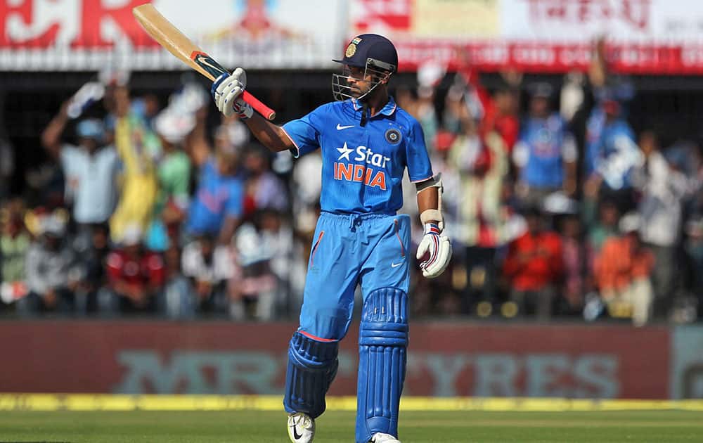 Ajinkya Rahane raises a bat after scoring 50 runs against South Africa during their second one day international cricket match between them in Indore.