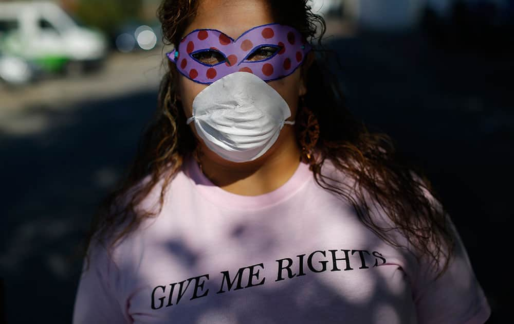 Mariela, who works as a prostitute, poses for a photograph as she covers her face so not to be recognised during a symbolic protest by prostitutes, in Madrid.