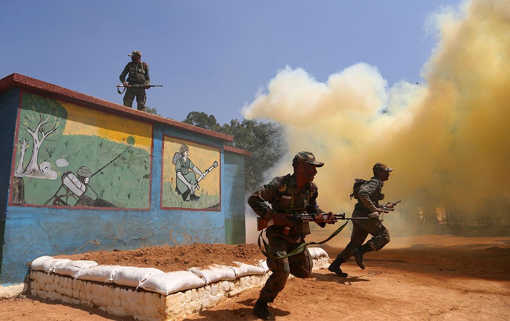 Indian army soldiers run after clearing an obstacle amid smoke from canisters to showcase their skills during a training session at army's Madras Engineer Group training centre in Bangalore, India.