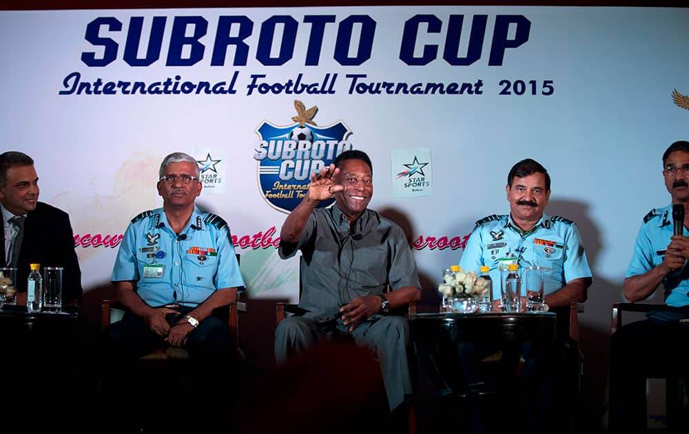 Brazilian football legend Pele gestures as he sits with Indian Air Force officials during a press conference in Gurgaon.