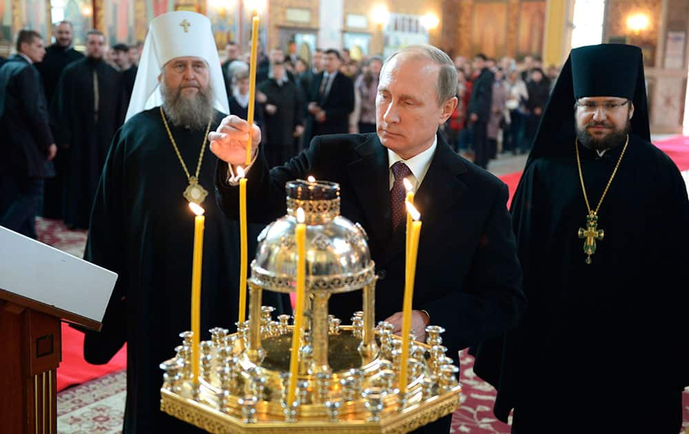 Russian President Vladimir Putin lights a candle as he visits the Assumption Cathedral in Astana, Kazakhstan.