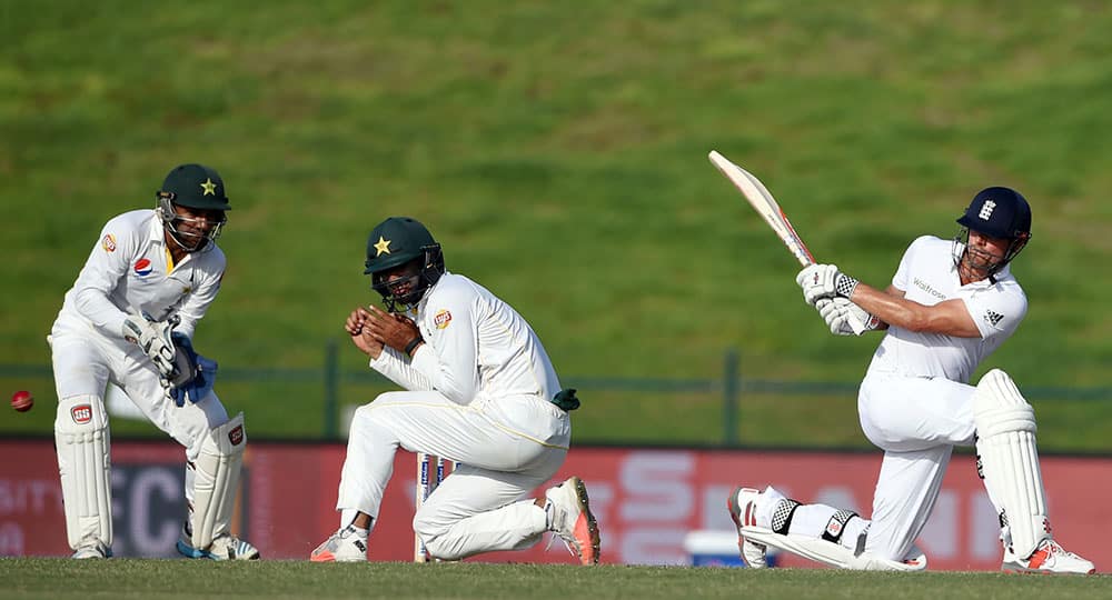 England captain Alastair Cook, right, hits a ball as Pakistan's Shan Masood protects himself during the third day of first test match between England and Pakistan at Zayed Cricket Stadium in Abu Dhabi, United Arab Emirates.