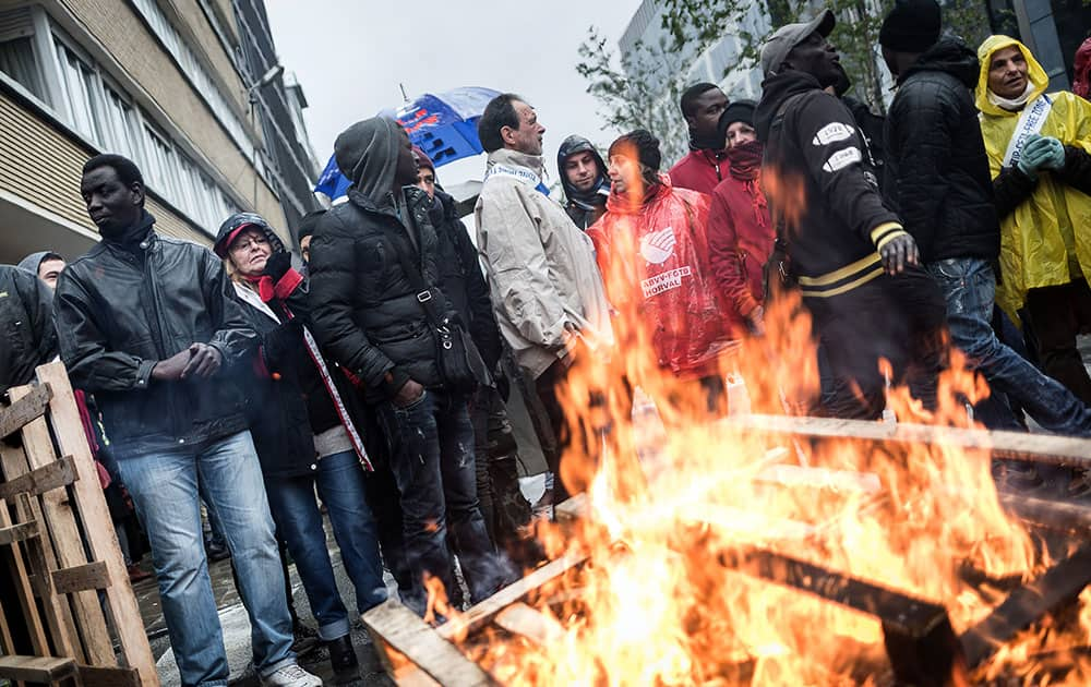 Demonstrators light a fire with wooden palettes outside of an EU summit in Brussels.