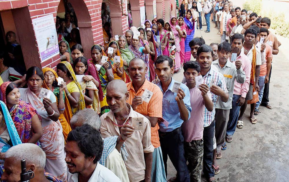 Voters wait in queues to cast their vote at a polling station during the second phase of Bihar assembly elections at Jehanabad.