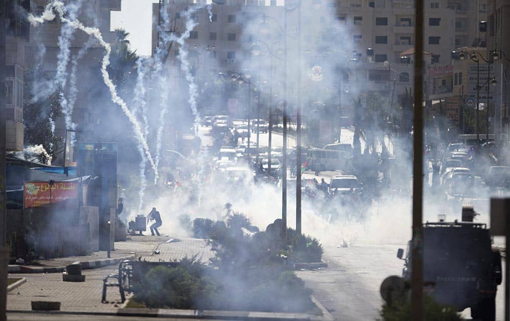 Israeli troops fire tear gas during clashes with Palestinian demonstrators near Ramallah, West Bank.