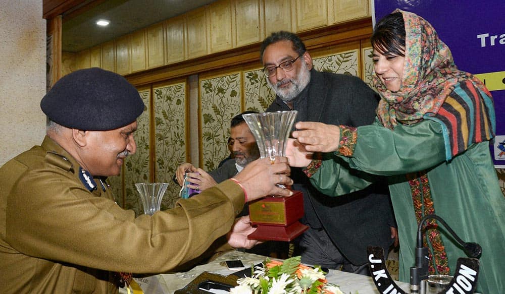 Director General of Jammu and Kashmir police K Rajindra presents a momento to Member Parliament and president of ruling party, PDP, Mehbooba Mufti as state Finance Minister Haseeb Drabu looks on during the inauguration of one day seminar on Isla-Traffic Management in J&K.