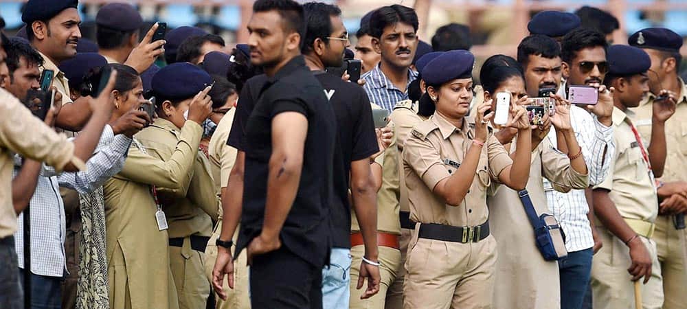 Police officials clicking pictures of cricketers during the India and South Africa practice session in Rajkot.