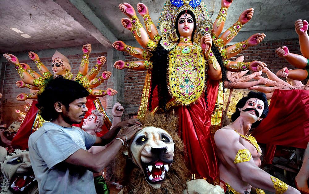 An Artist give final touches to idols of Goddess Durga ahead of the festival in New Delhi.