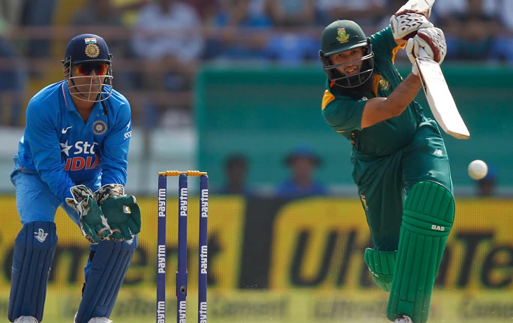 Mahendra Singh Dhoni watches South Africa's Hashim Amla, play a shot during their third one-day international cricket match in Rajkot.