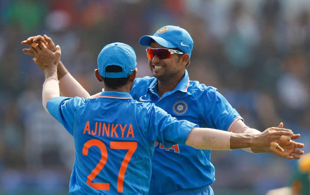 Ajinkya Rahane celebrates with teammate Suresh Raina after he took a catch to dismiss South Africa's David Miller during their third one-day international cricket match in Rajkot.