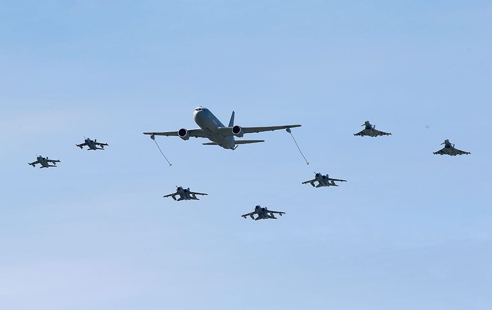 A Boeing KC-767 aerial refueling and strategic transport aircraft, center, flies along jet fighters during NATO Trident Juncture exercise 2015, in Trapani, Italy.