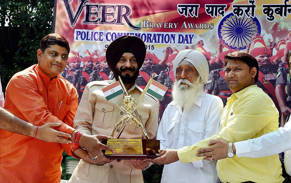 All-India Anti-Terrorist Front chairman M S Bitta presents Veer Bravery Award to Baljit Singh, a CRPF man who fought during Chinese aggression in 1959, in New Delhi.