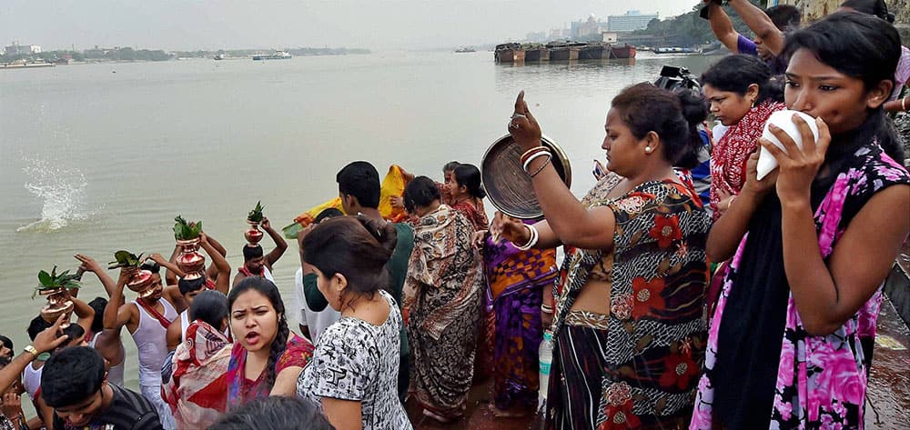 Hindu devotees perform a ritual on the occasion of Maha Saptami on the bank of the river Ganges in Kolkata.