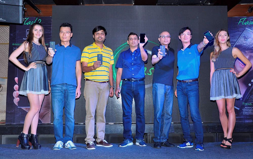 ALCATEL officials along with models displaying new ALCATEL FLASH 2 smartphone during the launch at F-Bar & Lounge in New Delhi.