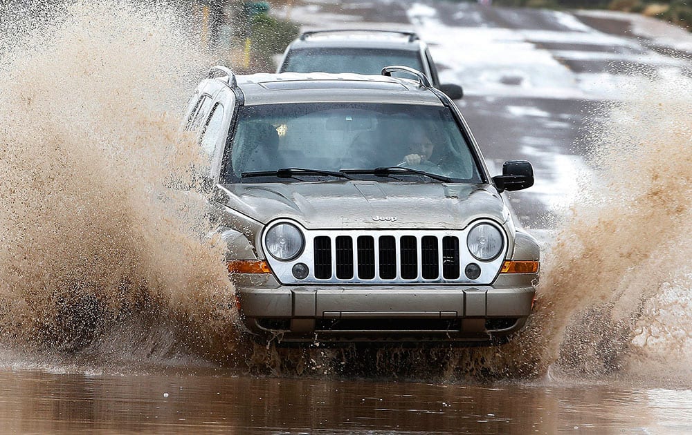 Drivers try to navigate flooded streets as severe storms move through in Desert Hills, Ariz. 