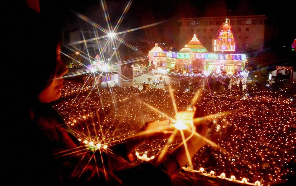 Thousands of devotees hold lamps to perform of 'Maha Arti' of Goddess Umiya on Durgashtmi at Umiyadham Temple in Surat.
