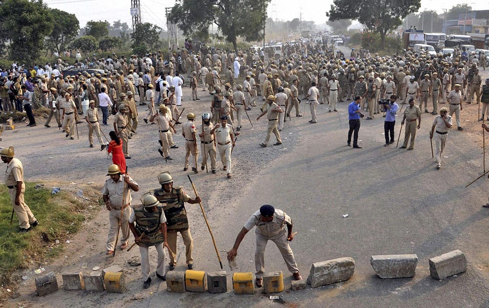 Police clearing a road that was blocked by the villagers during a protest against Sunpedh village incident in Faridabad.