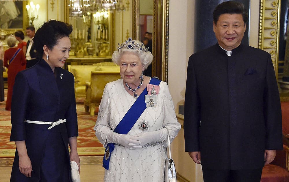Chinas President Xi Jinping and his wife Peng Liyuan, accompany Britains Queen Elizabeth and Prince Philip as they arrive for a state banquet at Buckingham Palace in London.