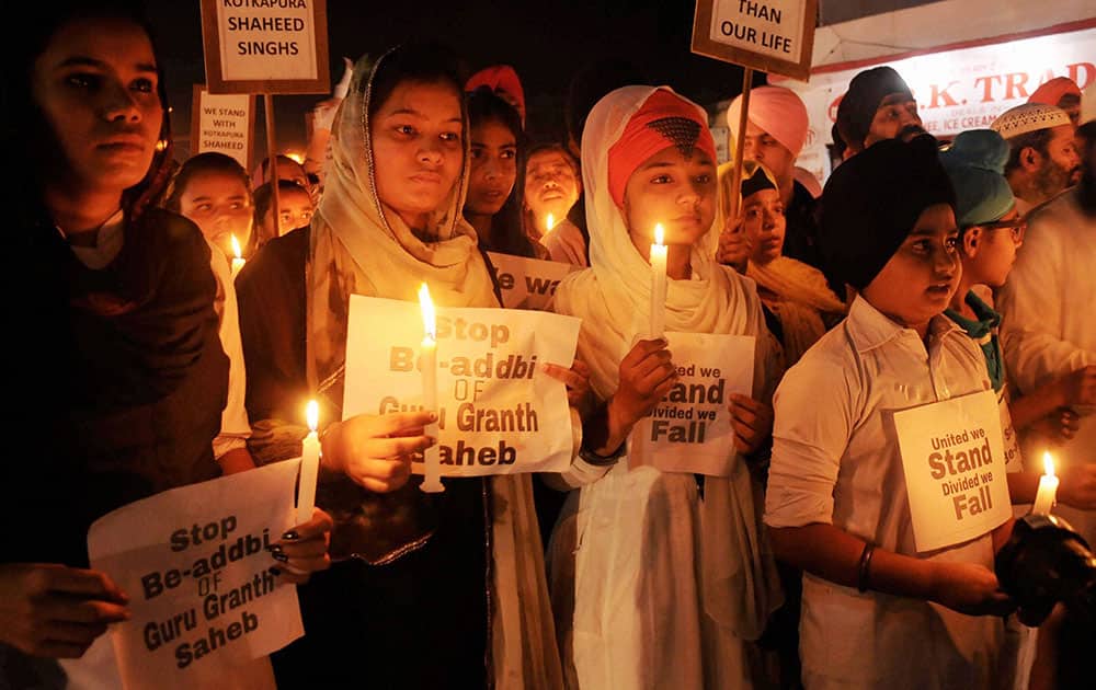 Sikhs Children taking out a candle march during their protest against the alleged desecration of religious book and Punjab firing incident in Amritsar.