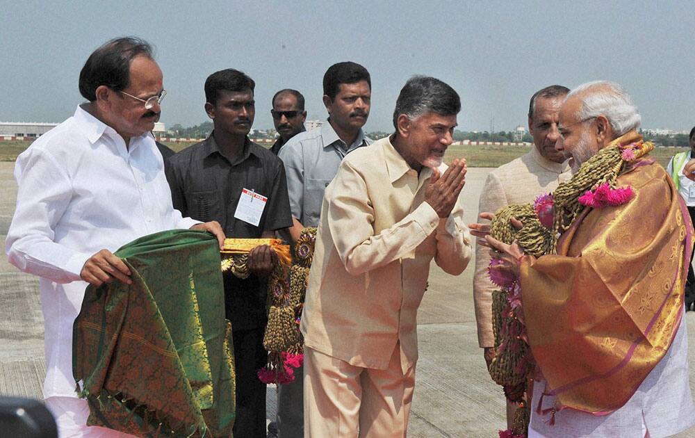 Prime Minister Narendra Modi being welcomed by the Union Minister for Urban Development, Housing and Urban Poverty Alleviation and Parliamentary Affairs, M. Venkaiah Naidu and the Chief Minister of Andhra Pradesh, N. Chandrababu Naidu on his arrival at Gannavaram Airport.