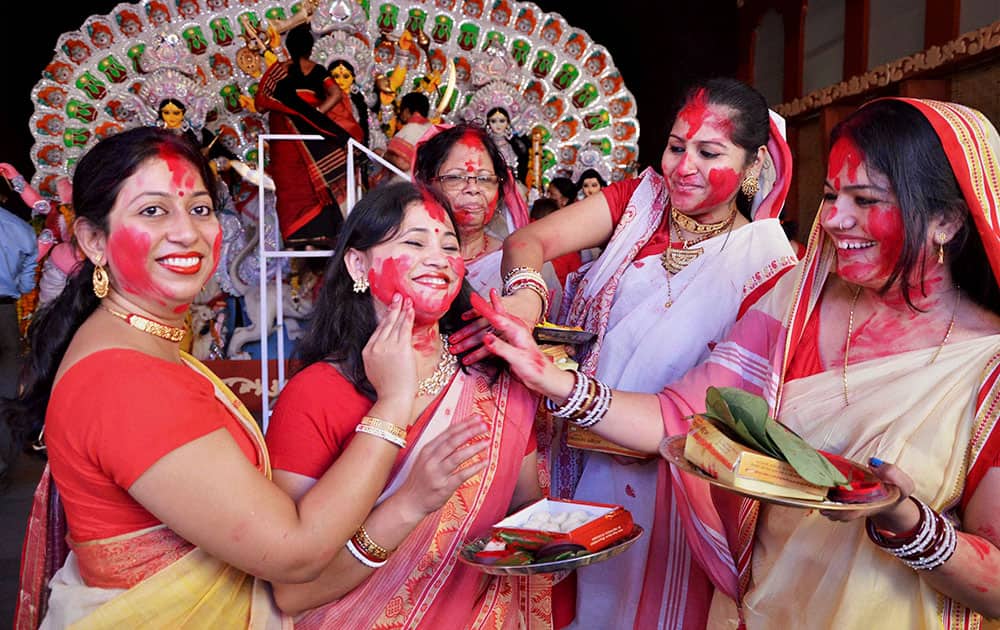 Married Bengali women play with vermilion during Sindur Khela on the last day of Durga Puja in Bhopal.