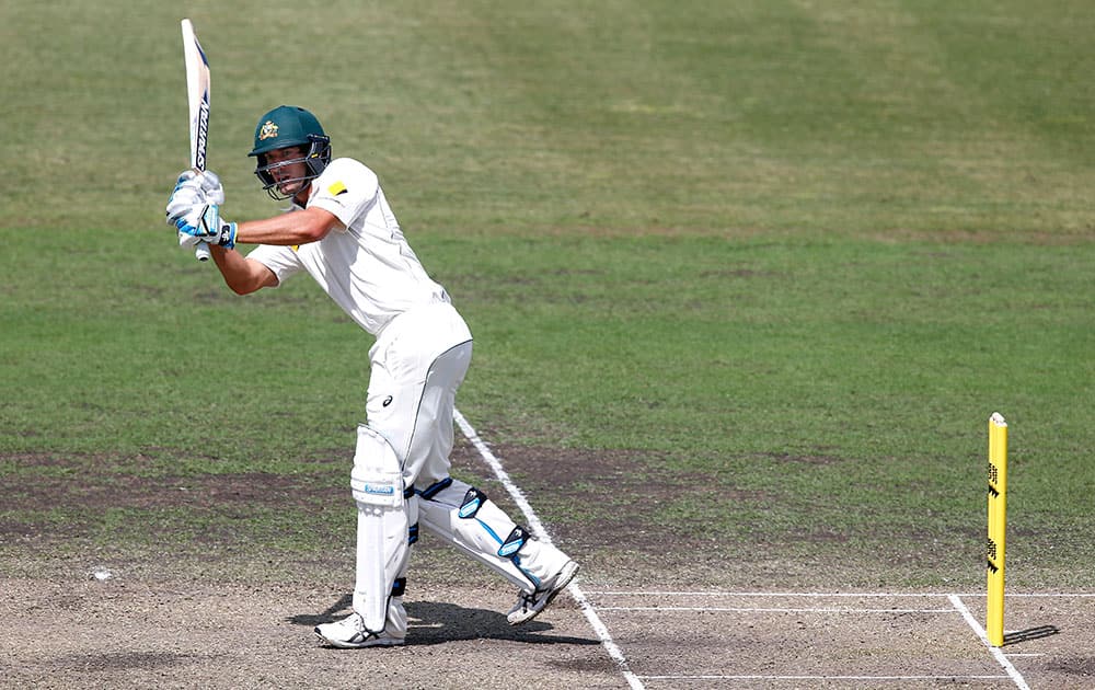 Joe Burns of Cricket Australia's XI hits the ball through the covers to reach his century from the bowling of New Zealand's Matt Henry in their cricket tour match in Canberra, Australia.