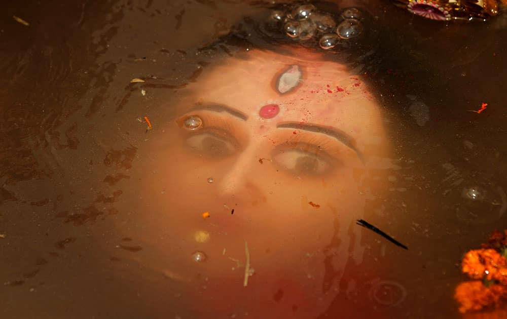 An idol of Hindu goddess Durga floats in water as devotees immerse the same in the River Kuakhai after the Durga Puja festival in Bhubaneswar, India.