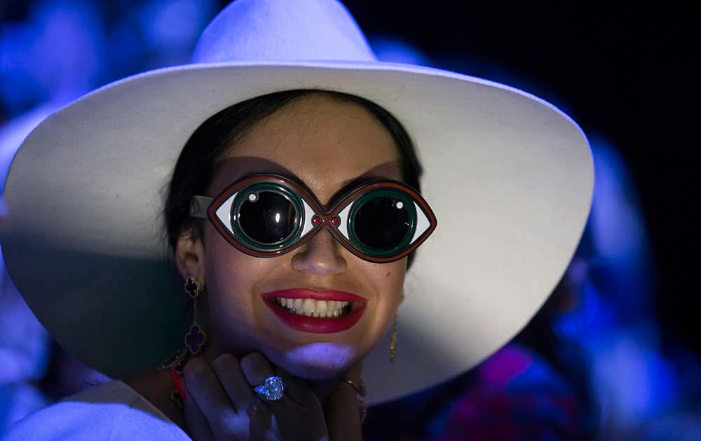 A spectator smiles while watching a model display a creation by Turkish designer Tarik Ediz during Fashion Week in Moscow, Russia.